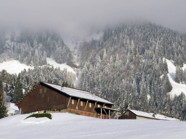 İsviçre çayırlarındaki yerli dağ kulübeleri ve ahşap ahırlar taze beyaz kar örtüsüyle kaplıdır, Nesslau - Obertoggenburg, İsviçre (Schweiz)