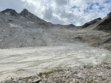 Silvretta Alp Dağları 'ndaki Fluela Wisshorn ya da Fluela Wisshorn (3085 m) zirvesinin altındaki dalgalı alp gölün çamurlu tabanı, Davos Kanton of Grisons, İsviçre (Kanton Graubuenden, Schweiz))