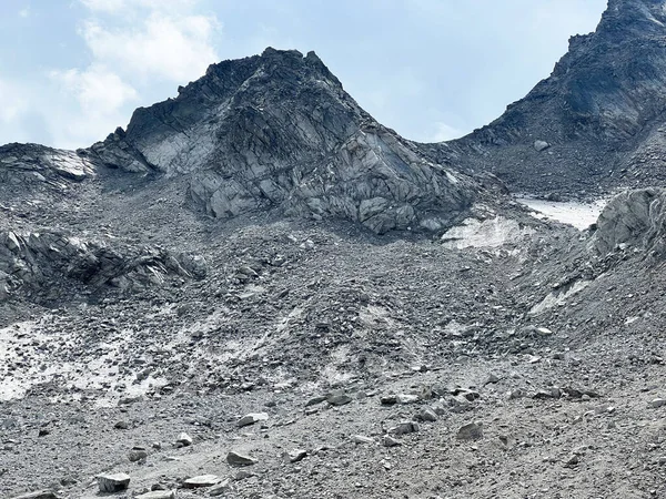Consequences of global warming and climate change - the last summer remnants of the Joerigletscher alpine glacier over the Fluelapass mountain road pass, Davos - Canton of Grisons, Switzerland (Kanton Graubuenden, Schweiz)