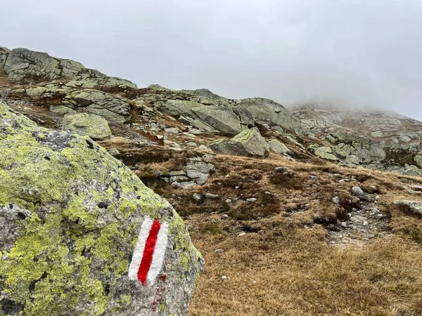 Mountaineering signposts and markings in the mountainous area of the alpine St. Gotthard Pass (Gotthardpass) and the massif of the Swiss Alps, Airolo - Canton of Ticino (Tessin), Switzerland (Schweiz)