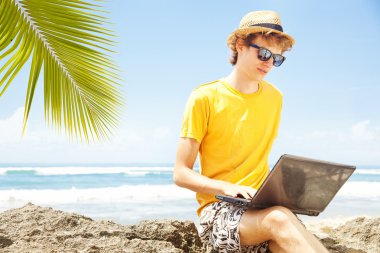 adam sahilde, bali laptop ile