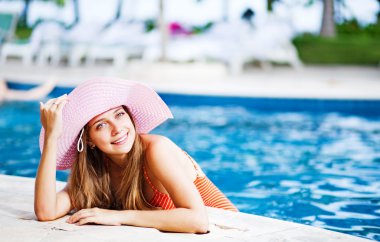 genç güzel kadın açık hava yüzme havuzu dışında görünüyor