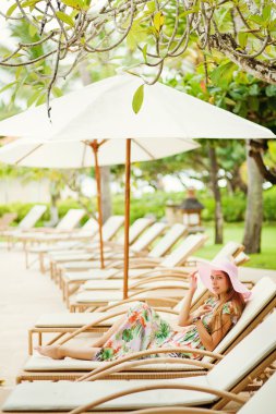 şezlong şemsiye altında açık havada genç güzel kadın