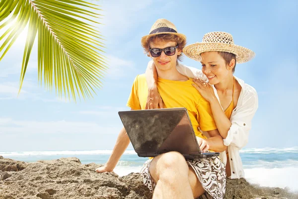 Пара с ноутбуком на пляже, бали — стоковое фото