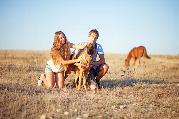 Brother and sister on a field — Stock Photo, Image