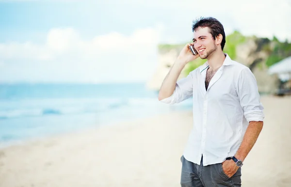 Young man with a phone near the sea. Bali, Indonesia. — Stock Photo, Image