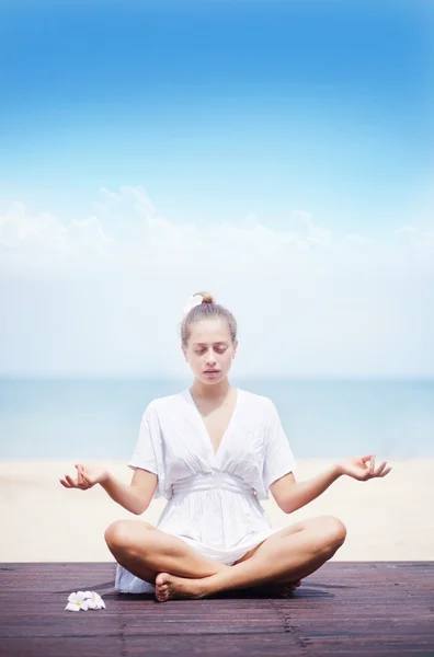 Ritratto di una giovane donna che pratica yoga in spiaggia — Foto Stock