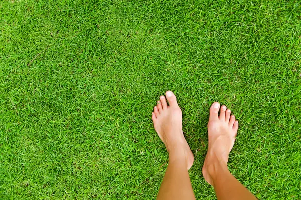 Foten över grönt gräs — Stockfoto