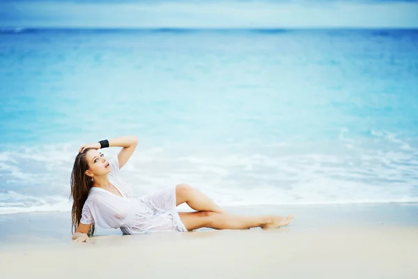 Mujer joven en la orilla del océano en vestido blanco — Foto de Stock