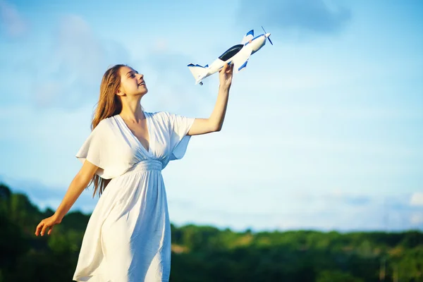 Jonge vrouw met speelgoed vliegtuig — Stockfoto