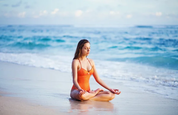 Młoda kobieta uprawia jogę na plaży — Zdjęcie stockowe