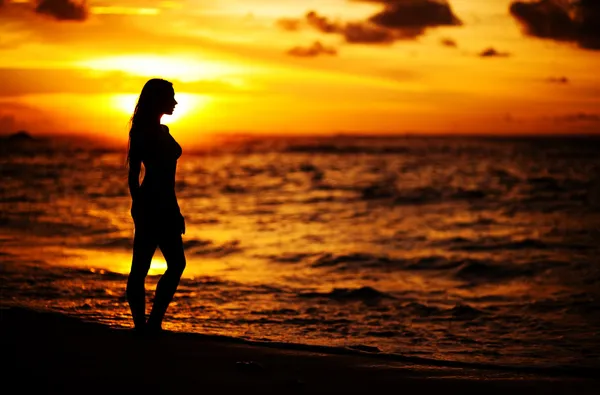 Woman silhouette in the sea splashing water — Stock Photo, Image