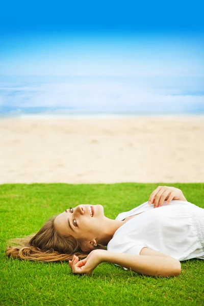 Jonge mooie vrouw op het groene gras — Stockfoto