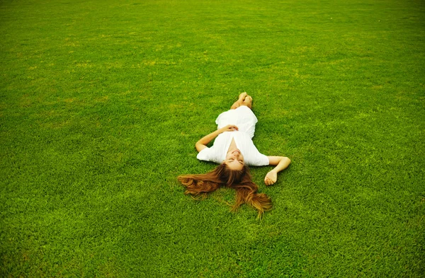 Jovem mulher bonita na grama verde — Fotografia de Stock