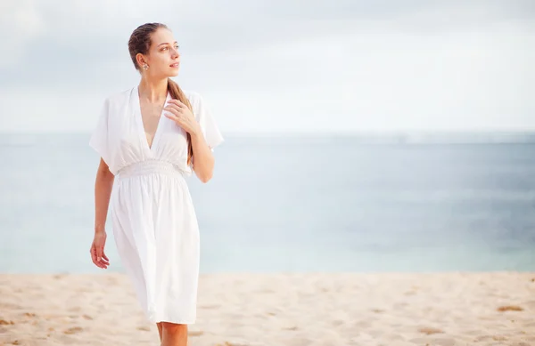 Jeune femme au bord de l'océan en robe blanche — Photo