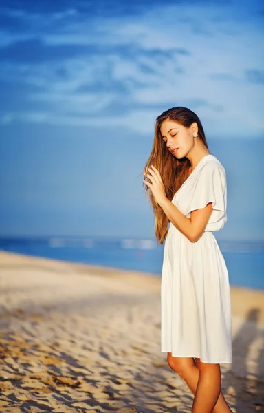 Jeune femme au bord de l'océan en robe blanche — Photo