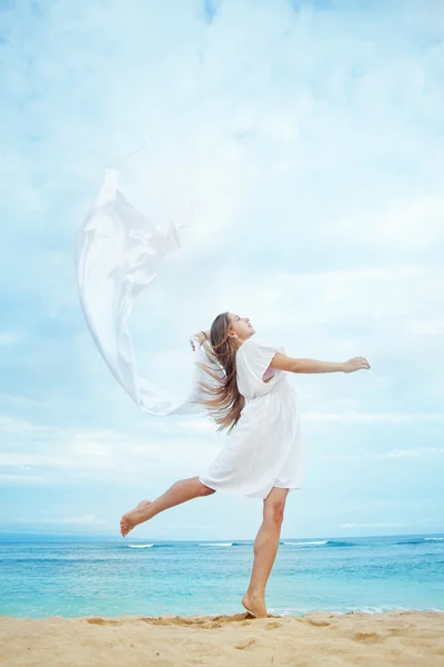 Jonge mooie vrouw met witte vlag in de buurt van de Oceaan, Indonesië, bali — Stockfoto