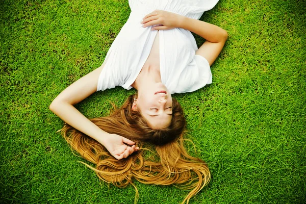 Mooie vrouw op het gras — Stockfoto