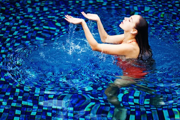 Jonge vrouw in het zwembad in luxe resort, bali, Indonesië — Stockfoto