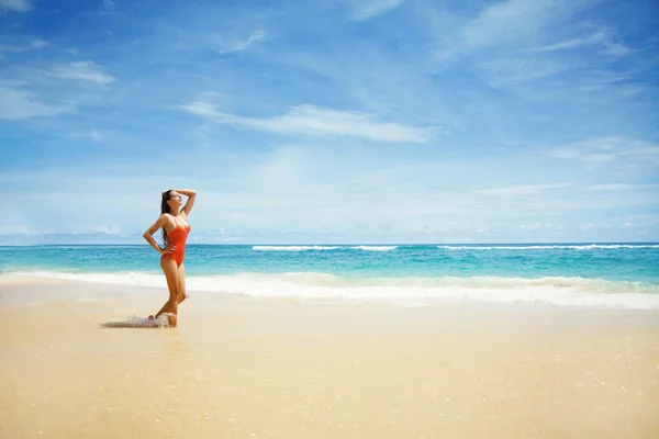 Jovem bela mulher molhada sentada na areia perto do oceano, Bali, Indonésia — Fotografia de Stock
