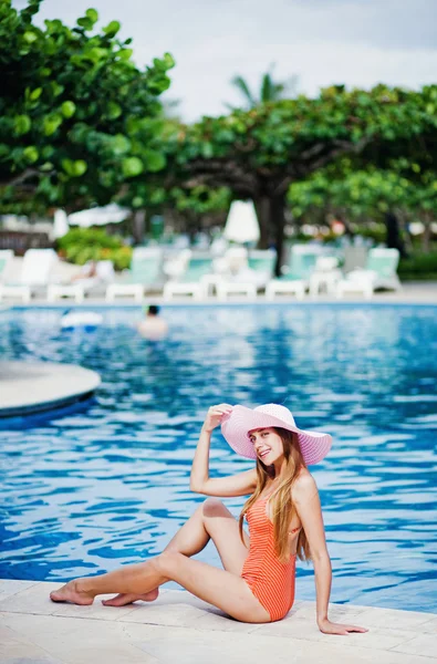 Giovane bella donna seduta vicino alla piscina — Foto Stock