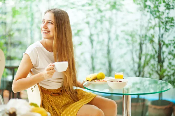 Vacker ung kvinna äter frukost (mjukt fokus) — Stockfoto