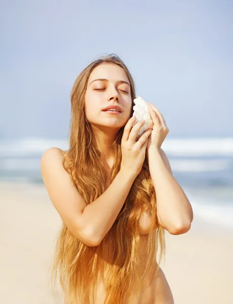 Красивая женщина с морской раковиной на пляже, бали — стоковое фото