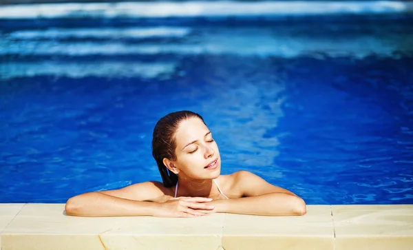Jonge mooie vrouw met plezier in zwembad in zonnige dag — Stockfoto