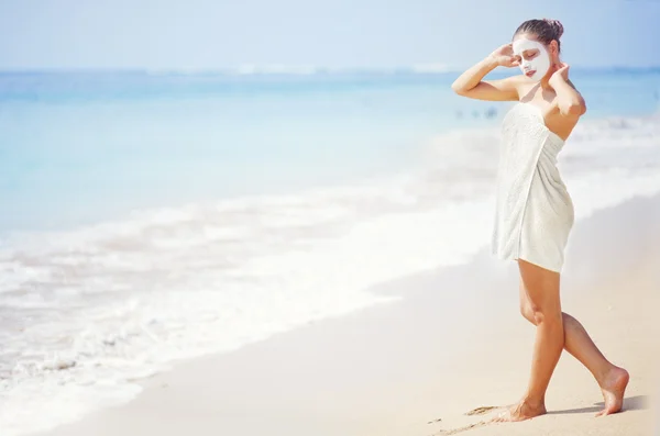 Donna sulla spiaggia con maschera sul viso — Foto Stock