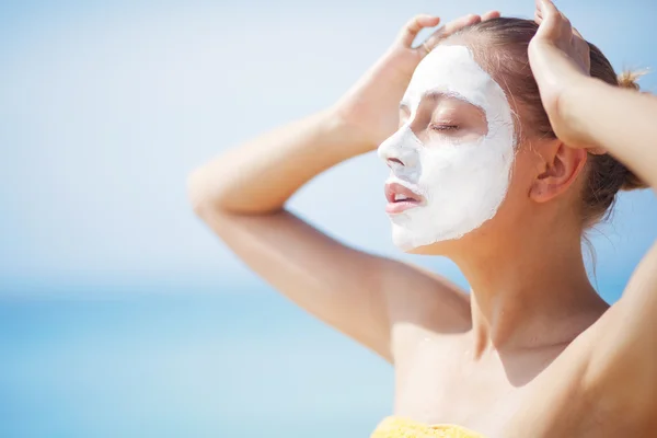 Sahilde bir kadınla yüz maskesi — Stok fotoğraf