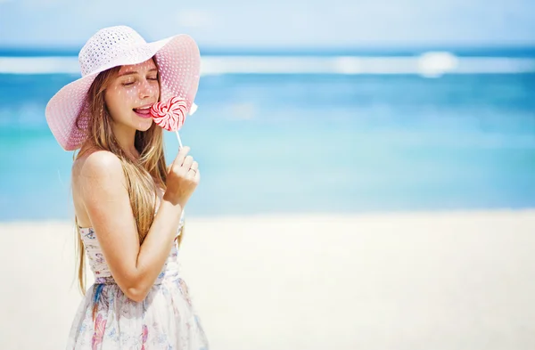 Día de San Valentín: Joven mujer caucásica con corazón de piruleta en la playa —  Fotos de Stock