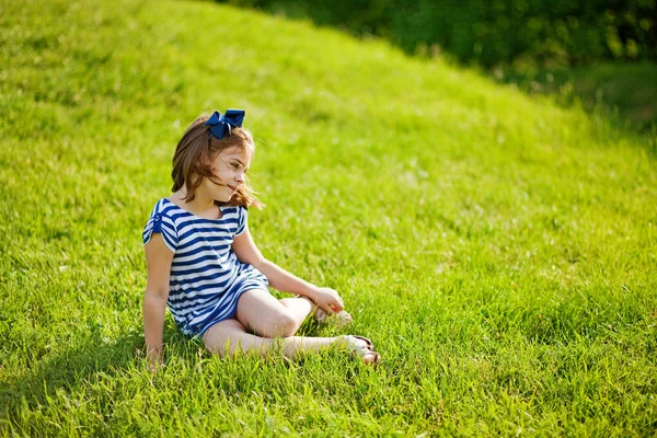 Liten flicka på gräset — Stockfoto