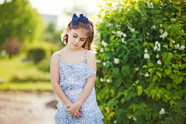 Klein meisje in de zomertuin — Stockfoto