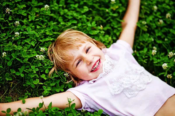 Szczęśliwy mało lyin dziewczyna na trawie — Zdjęcie stockowe