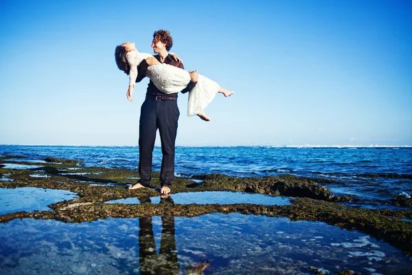 Man håller sin brud på händerna — Stockfoto