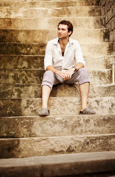 バリ島の階段に座っているハンサムな男 ストック写真