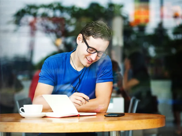 Joven emprendedor o estudiante trabajando en una cafetería — Foto de Stock