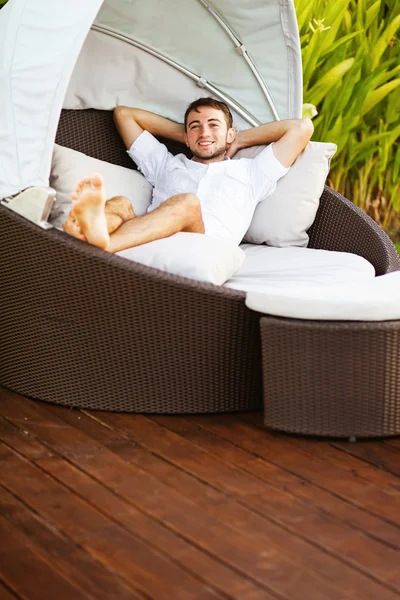 Hombre en una cama al aire libre en verano — Foto de Stock