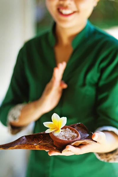 Masérka drží lázeňské přísady (měkké zaměření na květ a sůl) — Stock fotografie