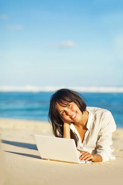 Woman with laptop on a beach Stock Picture