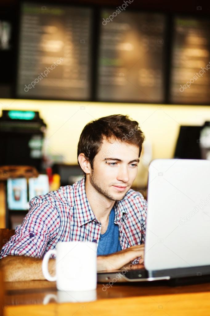 Serious man with laptop in cafe