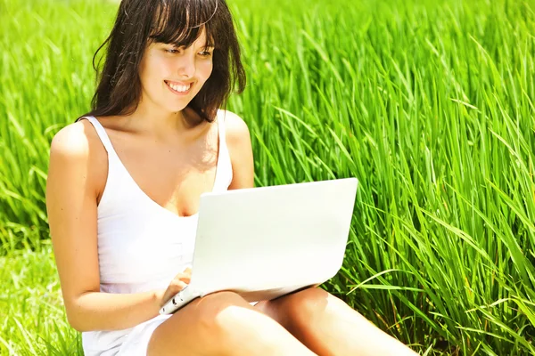 Jonge vrouw op het gras in park of tuin — Stockfoto