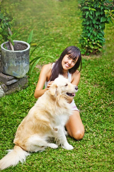 Kvinna leker med hennes hund i trädgården — Stockfoto