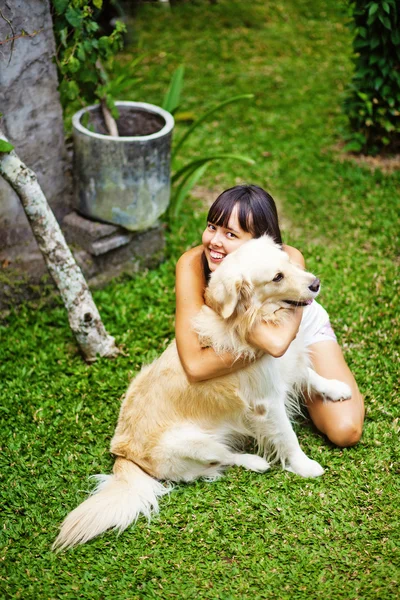 Kvinna leker med hennes hund i trädgården — Stockfoto