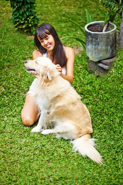 Kvinna leker med hennes hund i trädgården — Stockfoto