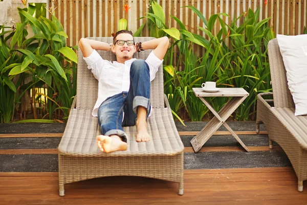 Hombre guapo en la tumbona en el jardín — Foto de Stock