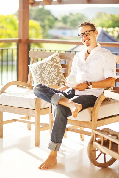 Homme à l'intérieur léger relaxant avec une tasse de café ou de thé — Photo