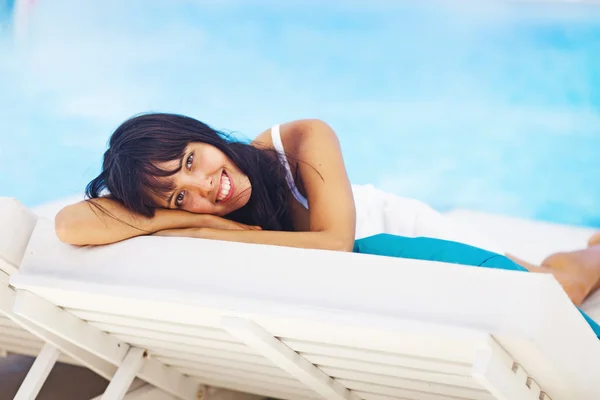 Woman relaxing in resort on a sunbed — Stock Photo, Image