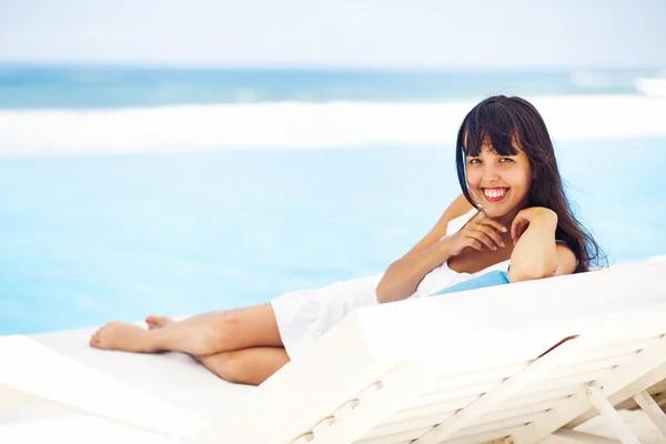 Frau entspannt sich im Resort auf einer Sonnenliege — Stockfoto