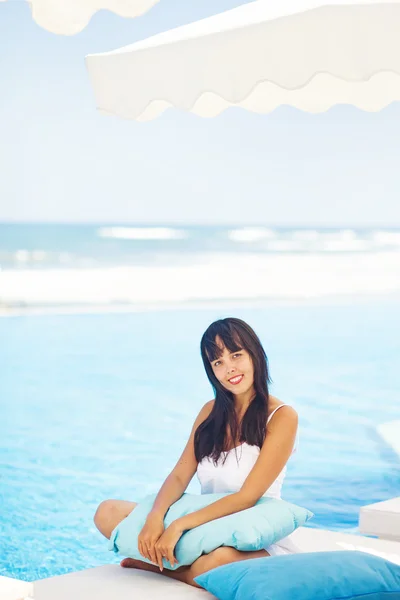 Kvinna på solstol nära pool — Stockfoto